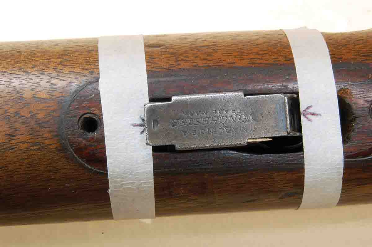 The tape indicates where wood filler pieces, front and rear, end against the magazine.